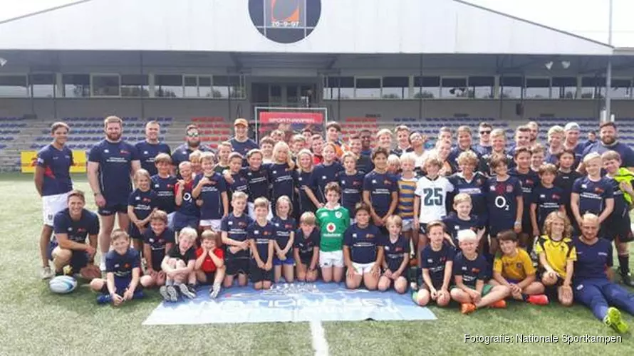 Jonge rugbyers krijgen training van internationals in het rugby stadion.