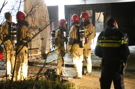 Brandweer helpt bewoners naar beneden na brand in portiek
