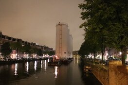 Metershoge silo’s door Amsterdamse grachten vervoerd