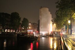 Metershoge silo’s door Amsterdamse grachten vervoerd