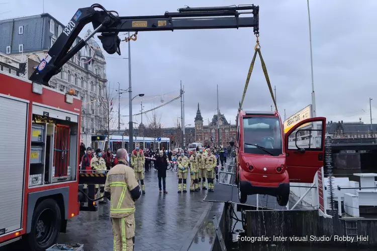 Canta brommobiel belandt in het water bij de Damrak in Amsterdam