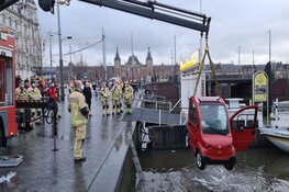 Canta brommobiel belandt in het water bij de Damrak in Amsterdam
