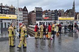 Canta brommobiel belandt in het water bij de Damrak in Amsterdam