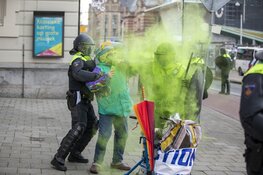 Oudere vrouw gooit poeder op agent bij Corona-rellen in Amsterdam