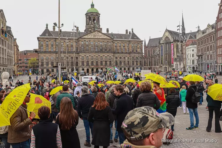 Demonstranten tegen coronamaatregelen lopen van Nieuwmarkt naar de Dam