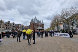 Demonstranten tegen coronamaatregelen lopen van Nieuwmarkt naar de Dam