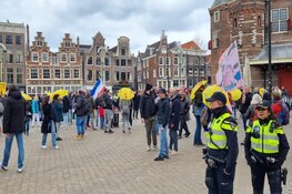 Demonstranten tegen coronamaatregelen lopen van Nieuwmarkt naar de Dam