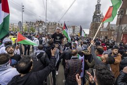 Demonstranten lopen van de Dam naar het Amstelstation