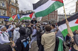 Demonstranten lopen van de Dam naar het Amstelstation