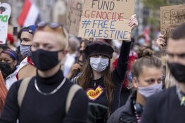 Demonstranten lopen van de Dam naar het Amstelstation
