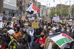 Demonstranten lopen van de Dam naar het Amstelstation