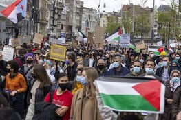 Demonstranten lopen van de Dam naar het Amstelstation