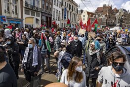 Demonstranten lopen van de Dam naar het Amstelstation