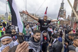 Demonstranten lopen van de Dam naar het Amstelstation
