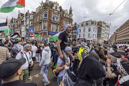 Demonstranten lopen van de Dam naar het Amstelstation