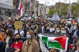 Demonstranten lopen van de Dam naar het Amstelstation