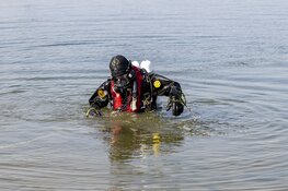 Brandweerduiker doet onderzoek naar mogelijk te water geraakt persoon