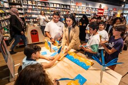 Stadsdeelvoorzitter Tanja Jadnanansing (Amsterdam-Zuidoost) en boer Ayoub laten boek signeren door jonge Amsterdamse schrijvers