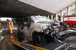 Auto in brand onder viaduct bij Muiden
