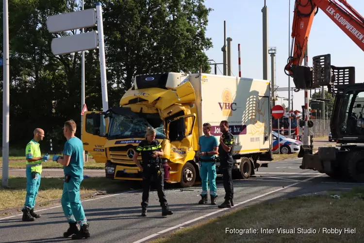 Graafmachine en vrachtauto in aanrijding met elkaar
