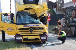 Graafmachine en vrachtauto in aanrijding met elkaar