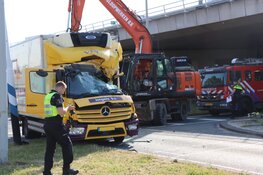 Graafmachine en vrachtauto in aanrijding met elkaar