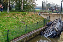 Auto op de kop in de sloot in Weesp, politie doet onderzoek