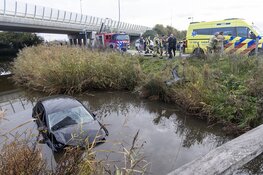 Automobilist te water langs de Osdorperweg in Amsterdam