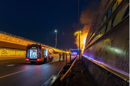 Persfotografen ontdekken brand en redden persoon uit brandend tentenkamp langs A10 in Amsterdam