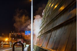 Persfotografen ontdekken brand en redden persoon uit brandend tentenkamp langs A10 in Amsterdam