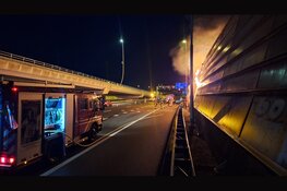 Persfotografen ontdekken brand en redden persoon uit brandend tentenkamp langs A10 in Amsterdam