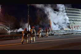 Persfotografen ontdekken brand en redden persoon uit brandend tentenkamp langs A10 in Amsterdam