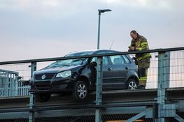 Automobilist rijdt bijna van Amsterdams parkeerdak en blijft meters boven grond hangen achter ijzer buis
